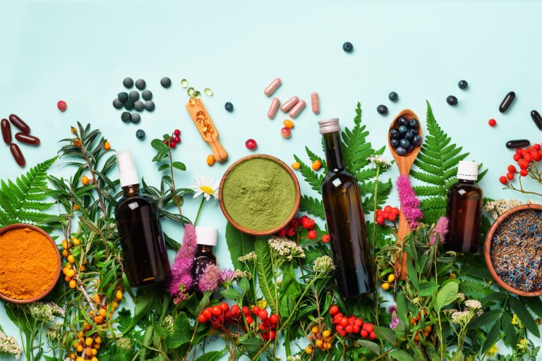 Verschiedene Heilpflanzen, Pulver, Kapseln und Flaschen mit pflanzlichen Extrakten für Pflanzenheilkunde und Phytotherapie auf weißem Hintergrund